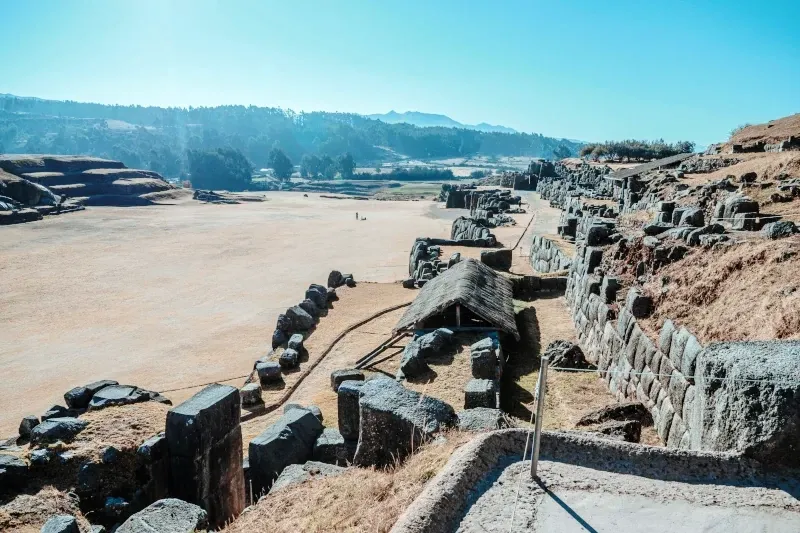 The large grassy esplanade and zigzagging stone walls of the Sacsayhuaman archaeological complex.