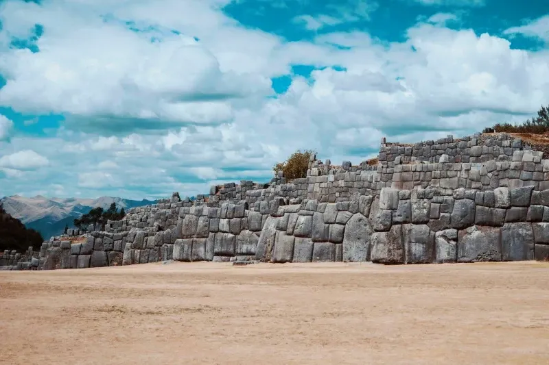 Impressive architectural view of the zigzagging defensive walls of Sacsayhuamán under a bright blue sky.