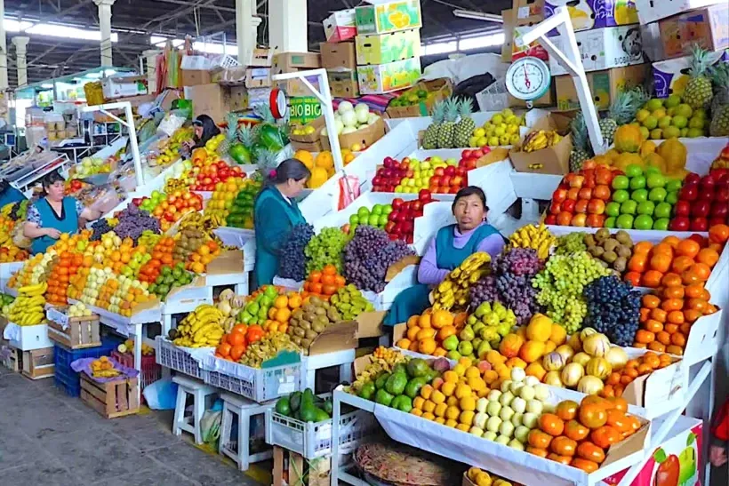 Local women selling a colorful variety of fresh Andean fruits at San Pedro Market in Cusco.