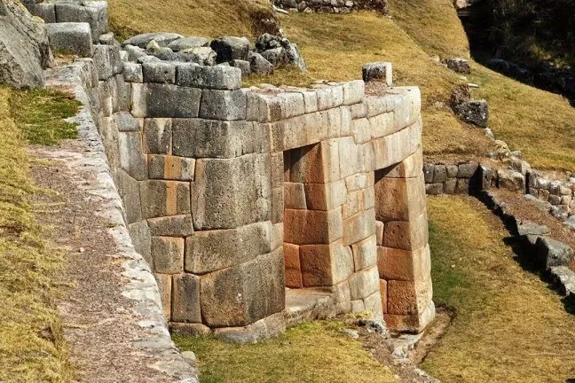Detailed view of a finely crafted Inca stone wall and doorway at the Tambomachay ruins.