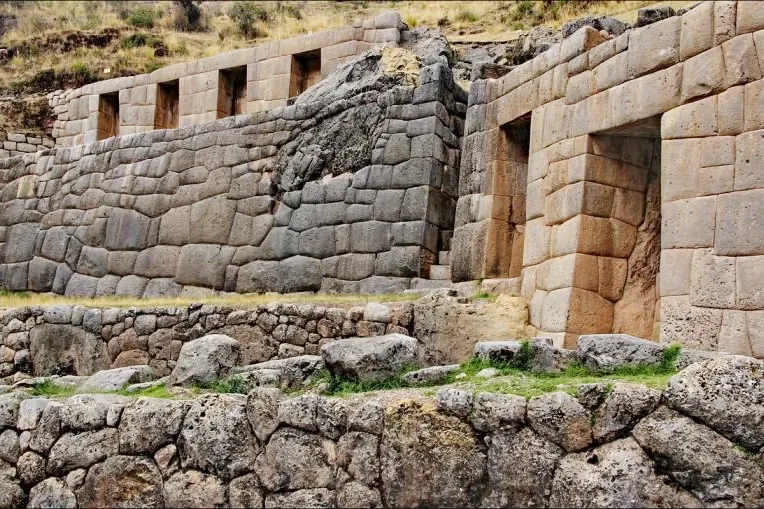 Ancient stone niches and multiple levels of terraces at the Tambomachay archaeological complex.
