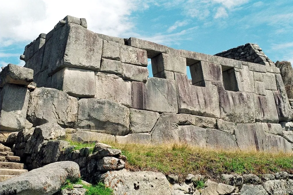 Side view of the massive stone structure of the Temple of the Three Windows, a highlight of Machu Picchu tours.
