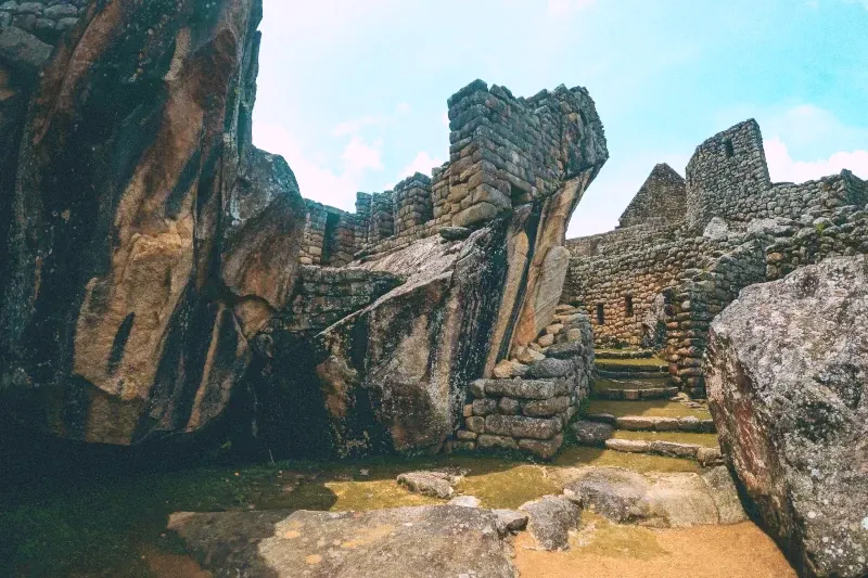 Ancient stone structures and natural rock formations at the Temple of the Condor in Machu Picchu.