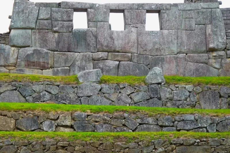 Temple of the Three Windows Architecture Detailed view of the Temple of the Three Windows with ancient Inca stone masonry and green terraces in Machu Picchu.