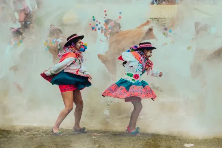 Peruvian dancers in vibrant traditional costumes and hats performing a rhythmic folk dance during a local festival.