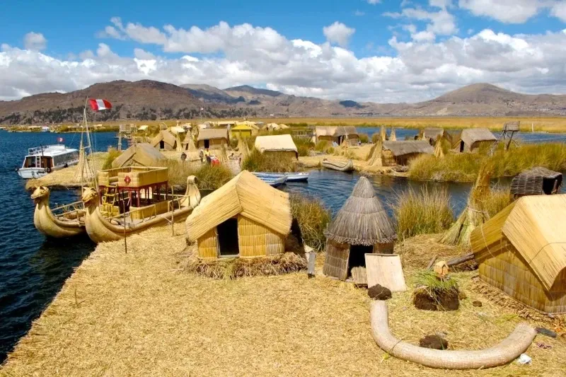 Panoramic view of the reed houses and traditional boats on the Uros floating islands.