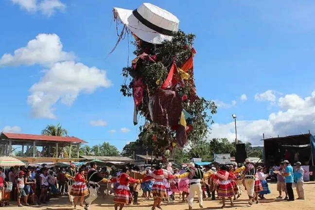 People celebrating around a decorated tree during the traditional Yunza festival.